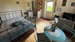 Una camera da letto con un letto, un comodino e una piccola scrivania con una sedia.