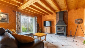 Ein gemütliches Wohnzimmer mit Kamin, Ledersofa und Fernseher.