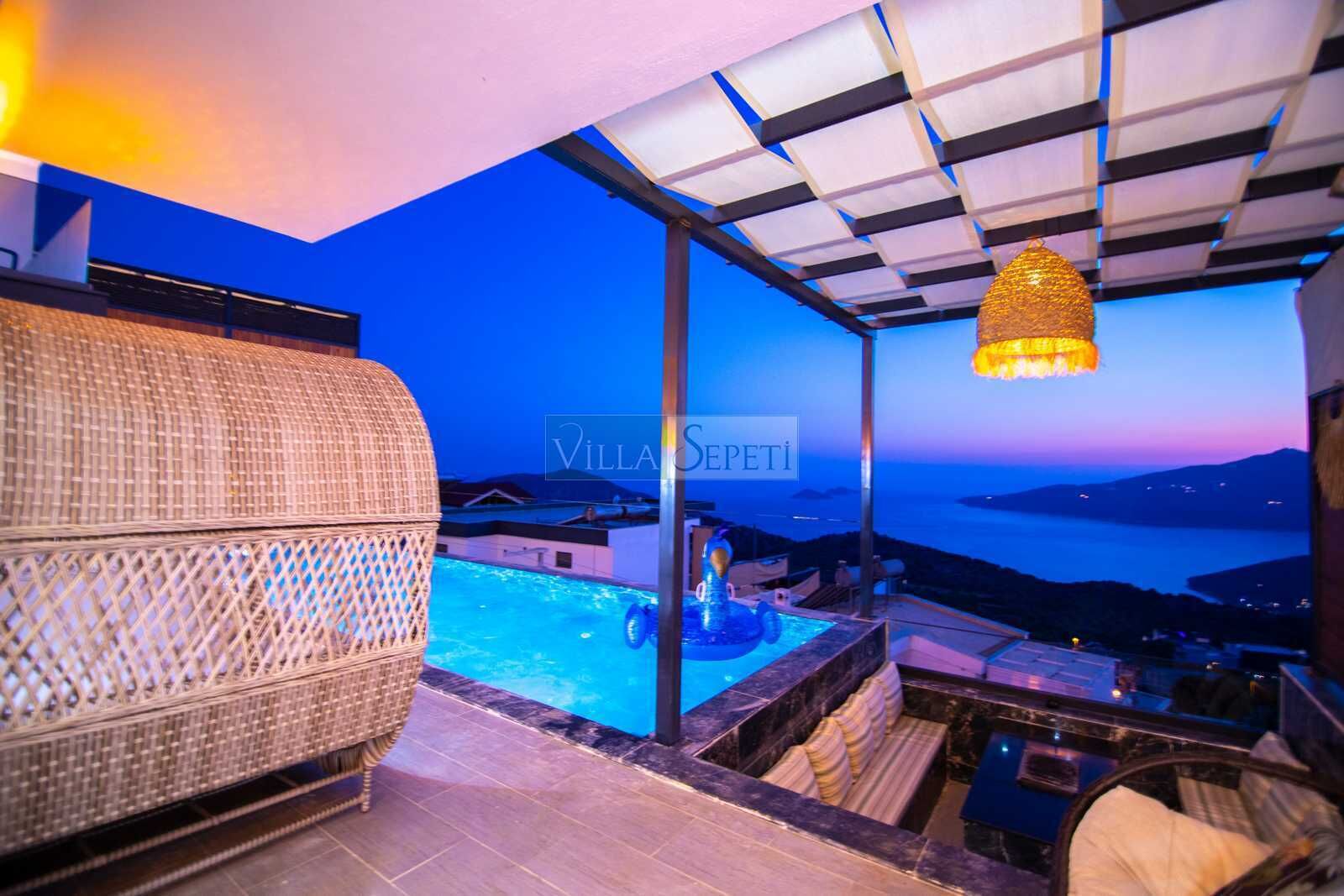 Un balcón con piscina, muebles de mimbre y una lámpara colgante.