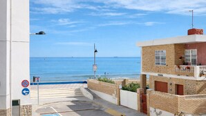 A coastal street with a view of the sea, a no parking sign, a wheelchair accessible parking space, and a building with a balcony. - Lovely home in Sueca with WiFi (Sueca)