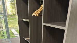 Ein moderner Kleiderschrank mit mehreren Einlegeböden und einer Kleiderstange aus Holz.