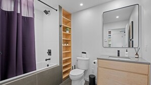 Un baño moderno con ducha, inodoro y tocador.