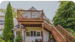 Ein Haus mit einer Holzterrasse, einer Treppe und einem Garten.