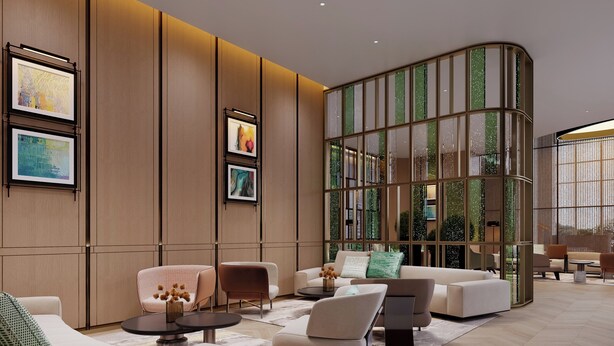 Um lobby moderno com divisória de vidro curva, assentos confortáveis e obras de arte emolduradas nas paredes.