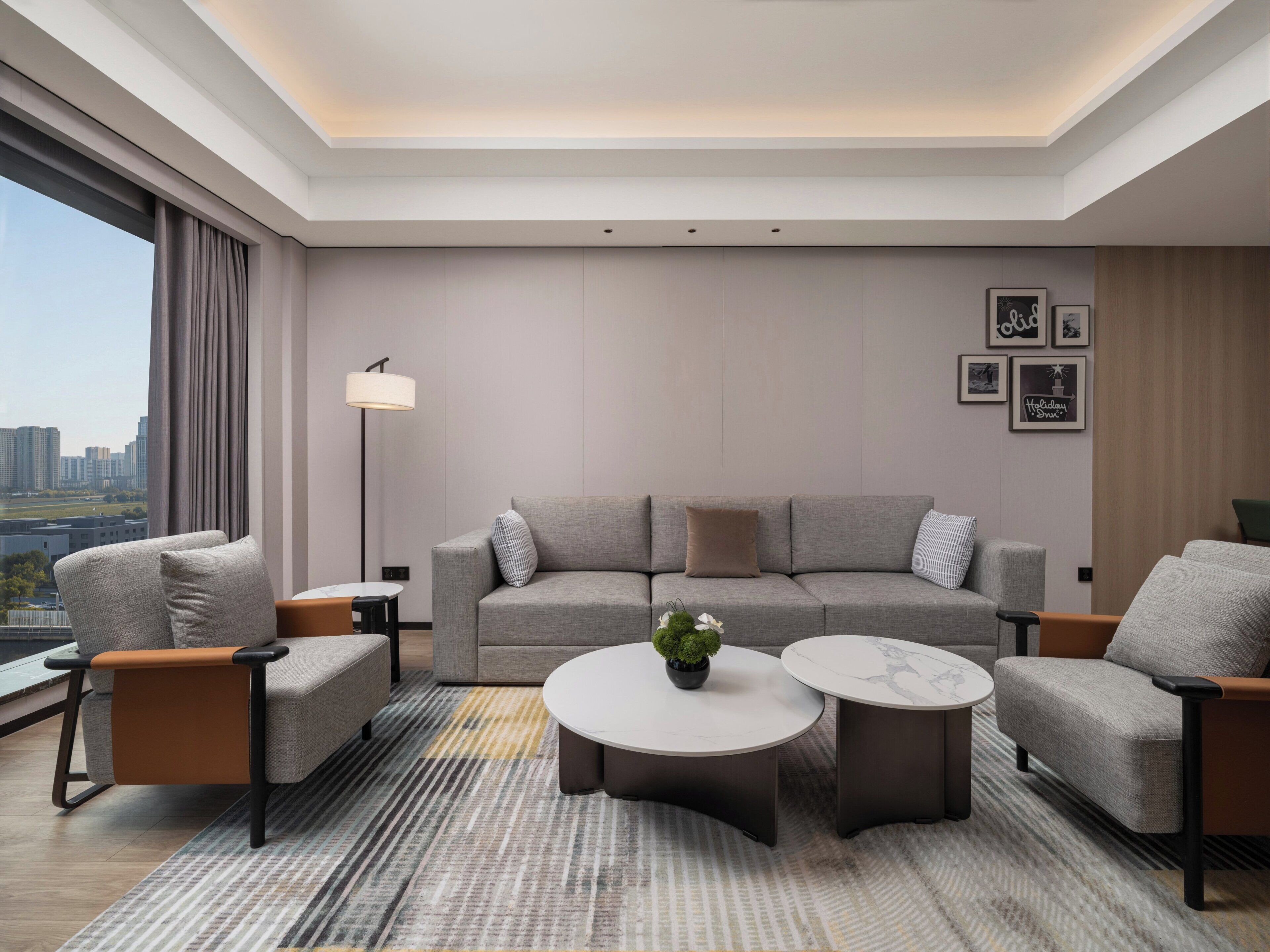 A modern living room with a sofa, armchairs, a coffee table, and a floor lamp.