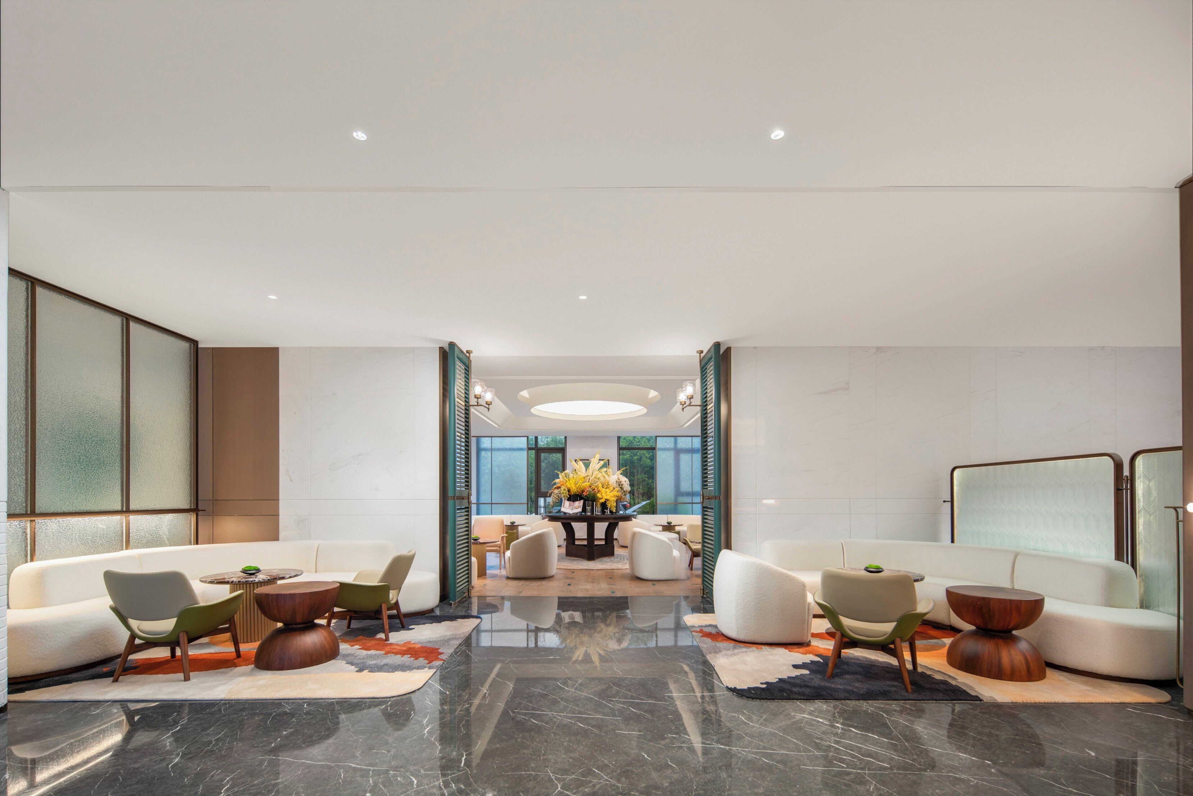 A spacious lobby with a central dining area, seating arrangements, and a modern design.