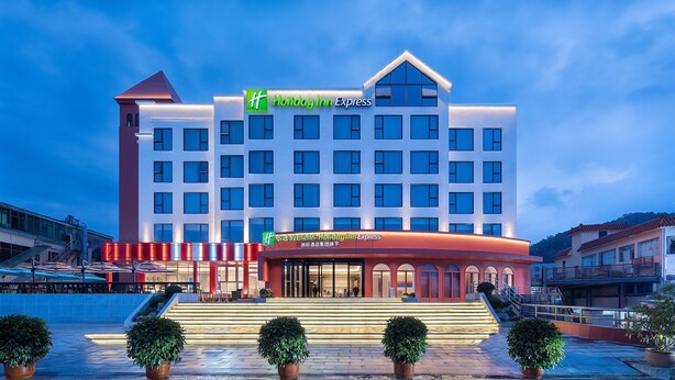 A Holiday Inn Express hotel with a modern design, featuring a prominent entrance, multiple floors, and a well-lit facade.