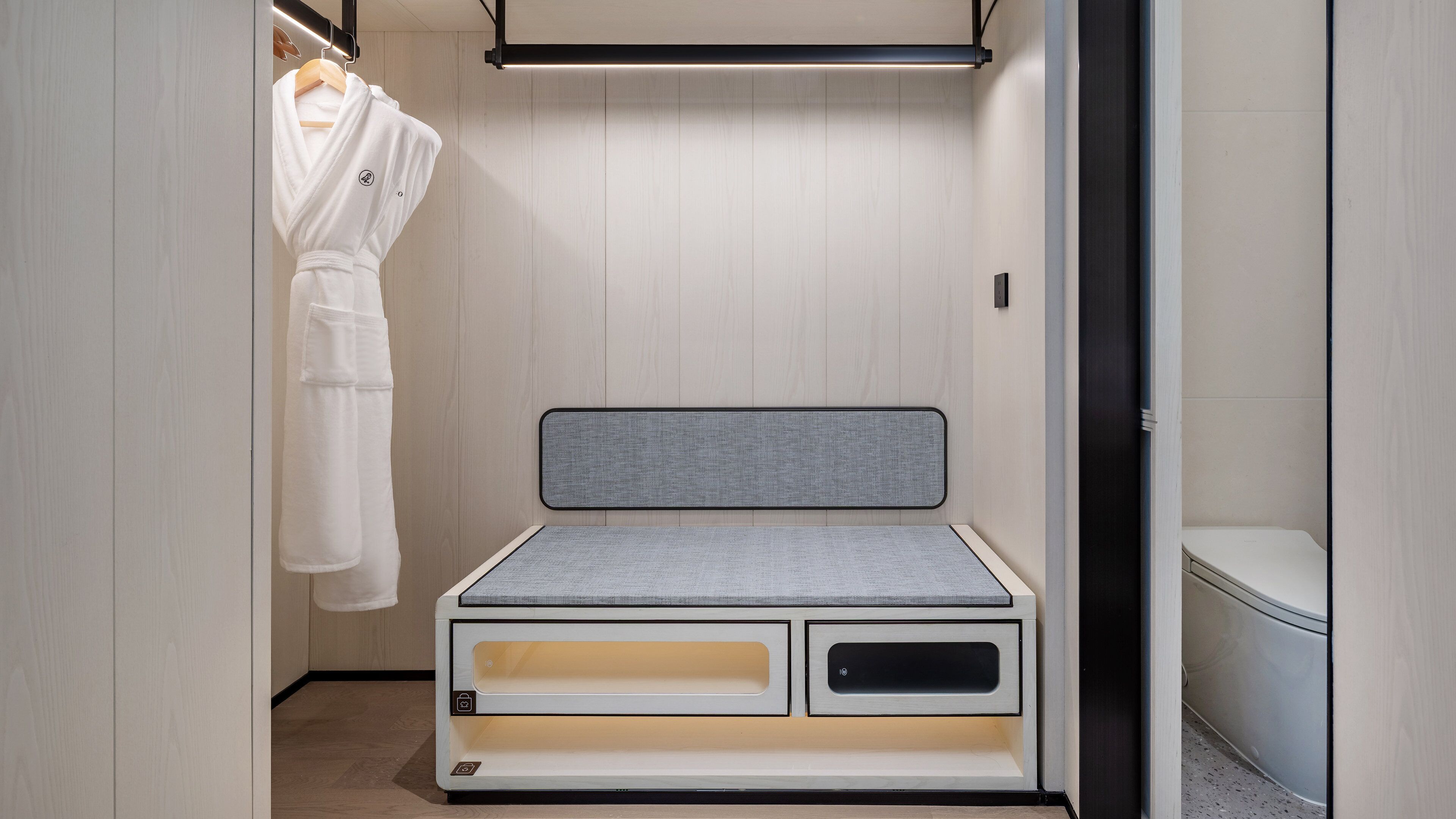 A compact room with a bed, a wardrobe, and a toilet.