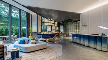 A modern interior with a seating area, a bar, and a view of greenery outside.