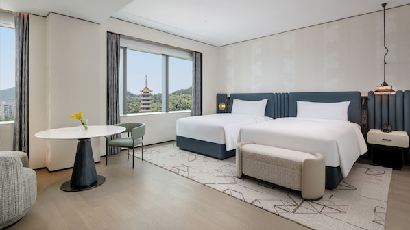 A hotel room with two beds, a small table, a chair, and a view of a pagoda. - Xiamen Sm City By Ihg (Xiamen)