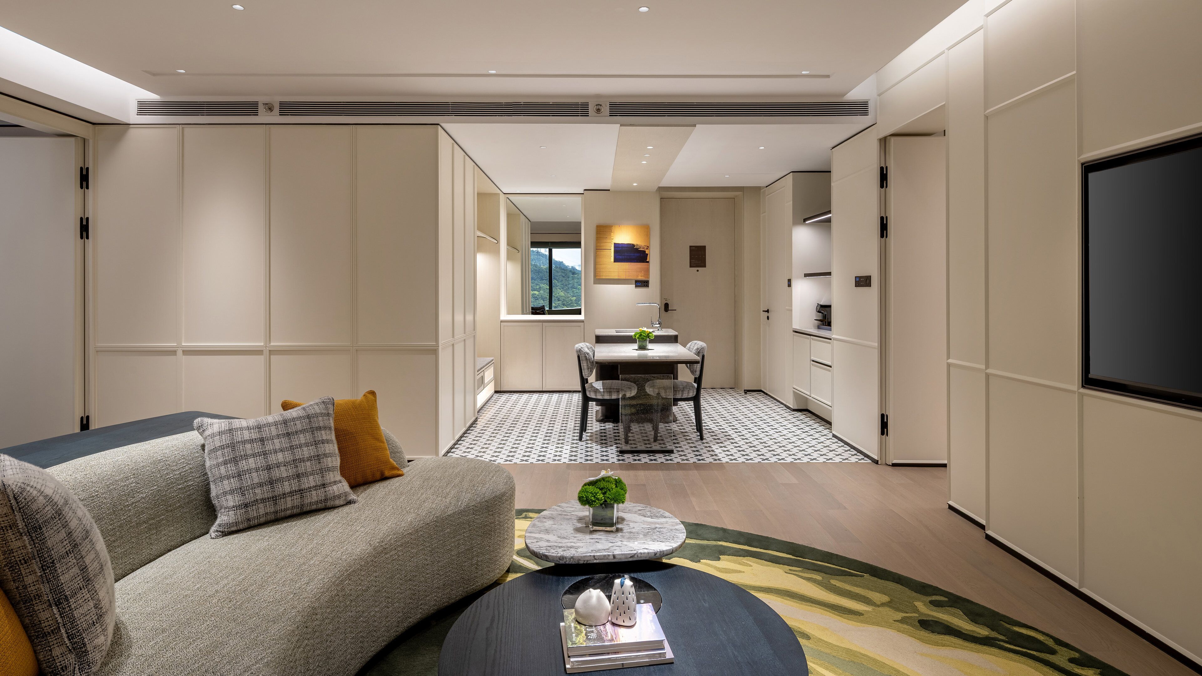 Een moderne woonkamer met een bank, salontafel en een televisie.
