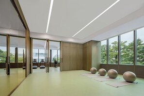 Una habitación moderna con ventanas amplias, pelotas de ejercicio y una esterilla de yoga.