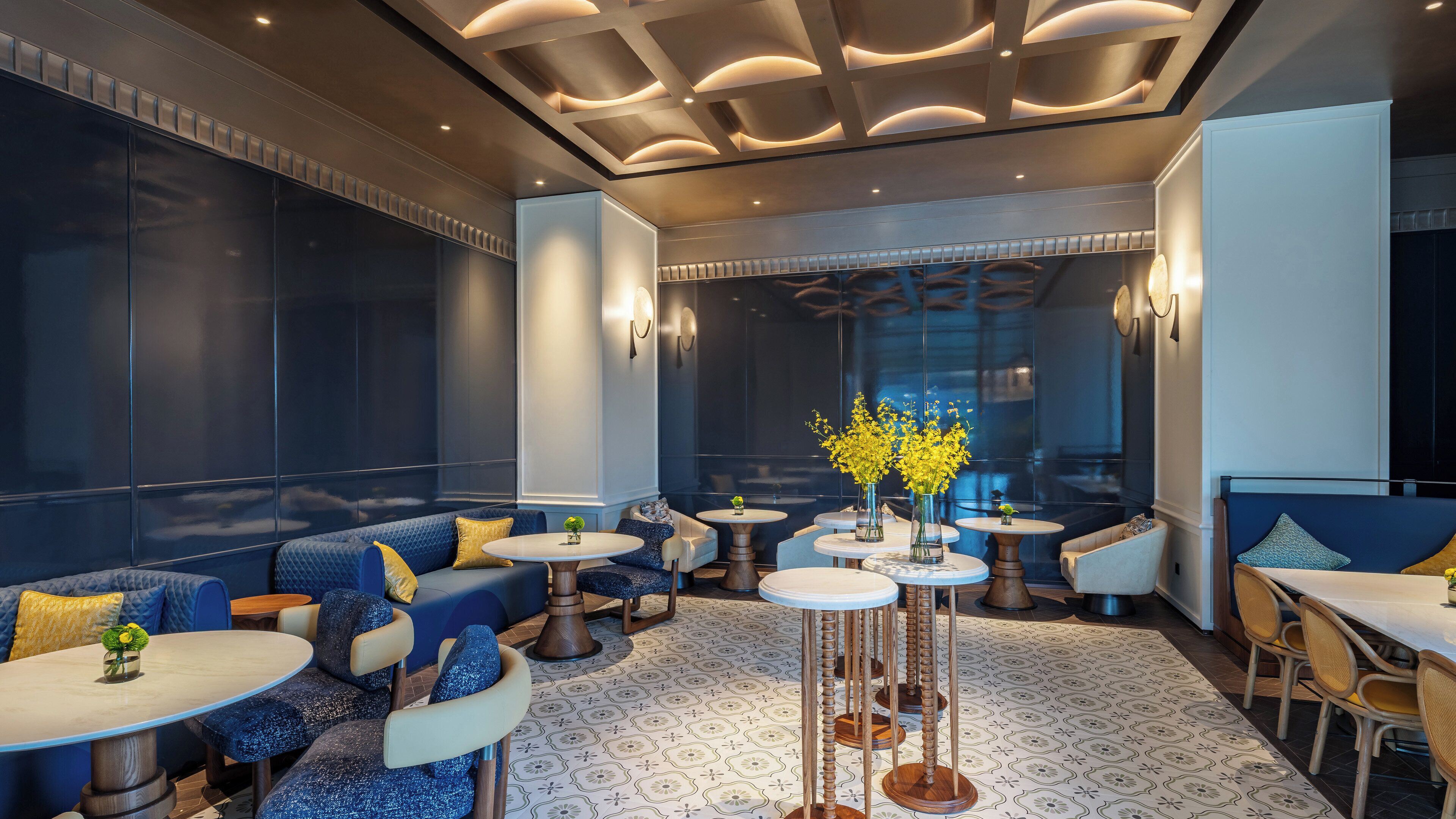 A modern lounge area with seating, tables, and decorative lighting.