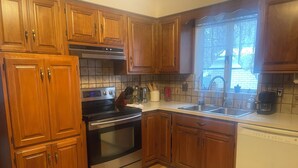 A kitchen with wooden cabinets, stainless steel appliances, a window with a view, and a tiled backsplash. - Spacious 3BR/2Bath Home - Retreat w/ Modern Amenities (Harper Woods)
