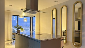 Una cucina moderna con isola centrale, ampie finestre e vista sulla città.