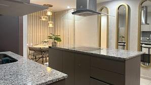 Una cucina moderna con piani in granito, elettrodomestici in acciaio inossidabile e un'isola centrale.