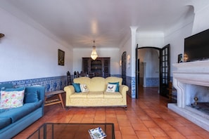 A living room with a sofa, a coffee table, a fireplace, and a television. - Almeirim House (Almeirim)