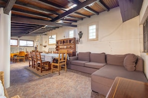 A spacious living area with a wooden dining table, chairs, and a sofa. - Almeirim House (Almeirim)