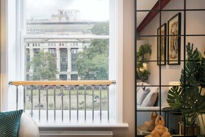 Ein Zimmer mit großem Fenster und Balkon mit Blick auf ein Gebäude.