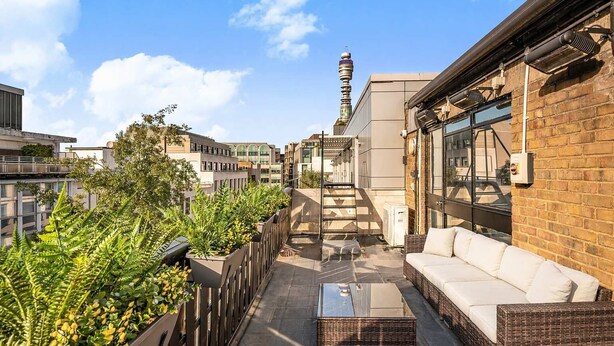A rooftop terrace with outdoor seating, a staircase, and a view of a tower in the distance. - Lumina House - Fitzrovia - by Frankie (London)