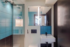 A modern bathroom with a shower, a sink, and a mirror. - The Influencer Suite - Soho - by Frankie Says (London)