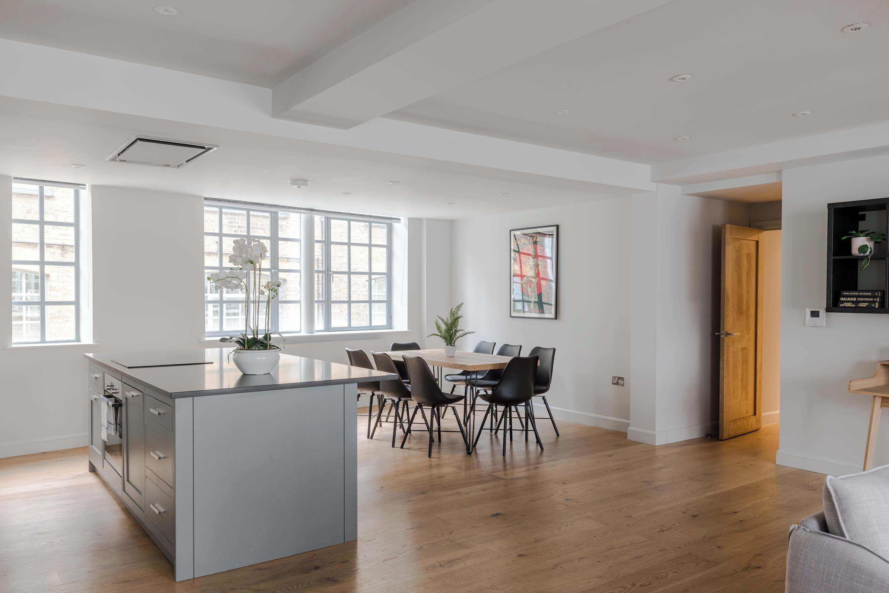 Ett rymligt kök med matplats, stora fönster och en modern design.