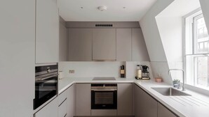 Una cocina moderna con electrodomésticos integrados, una ventana y un fregadero.