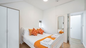 A bedroom with a bed, a wardrobe, a mirror, and a bathroom door. - The Cutesy - Fitzrovia - by Frankie Says (London)