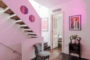 A staircase with a pink wall and a chair in the foreground. - A Starry Starry Night - Borough - by Frankie Says (London)