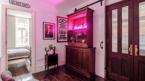 Ein Flur mit leuchtendem Neonlicht, einem Vintage-Schrank und einer Tür mit Zugriegel.