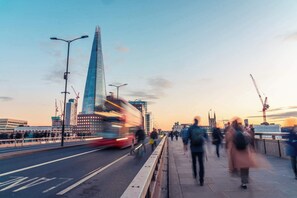 A busy urban street with a prominent glass skyscraper, a red double-decker bus, and pedestrians. - A Starry Starry Night - Borough - by Frankie Says (London)