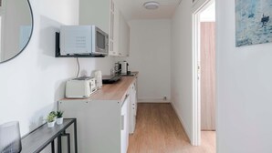 A compact kitchen with a microwave, toaster, and sink. - Wonderland - Fitzrovia - by Frankie Says (London)