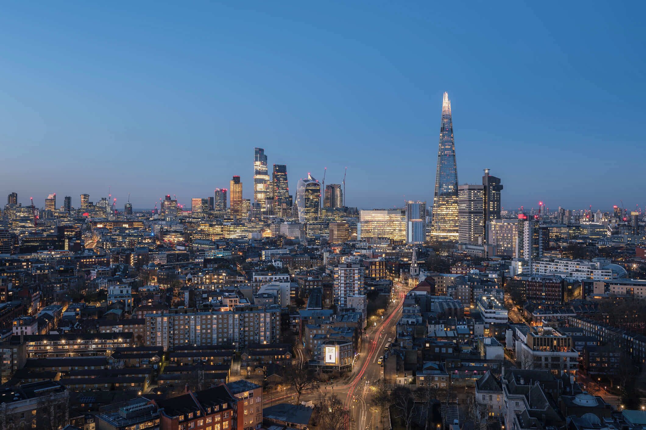 A cityscape with a prominent skyscraper, dense urban buildings, and a network of roads.