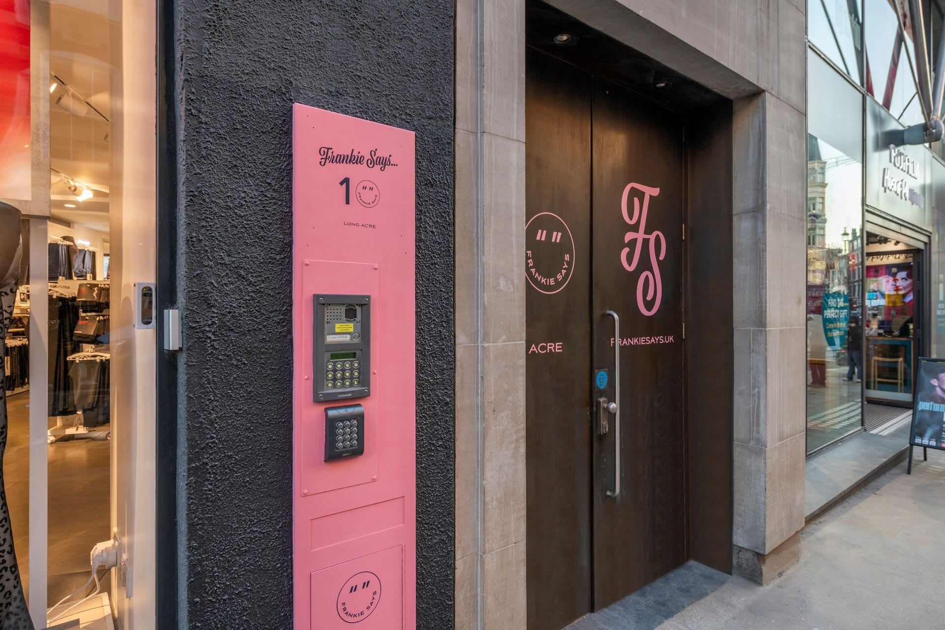 A storefront with a pink panel displaying a keypad and the text 'Frankie Says... 1'.