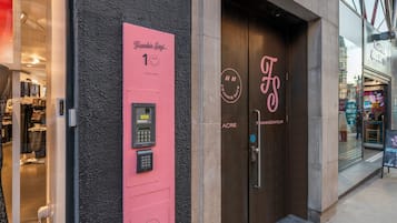 A storefront with a pink panel displaying a keypad and the text 'Frankie Says... 1'.
