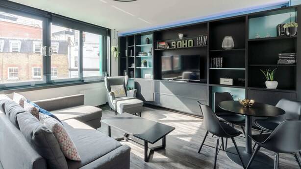 A modern living room with a sofa, chairs, a coffee table, a bookshelf, and a dining table. - The Slaycation Crib: Stylish London Retreat By (London)