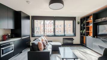 Een moderne keuken met inbouwapparatuur, een bank en een eethoek met een tafel.