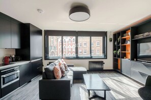 Une cuisine moderne dotée d’appareils électroménagers intégrés, d’un canapé et d’un coin repas avec une table.