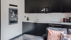 Una cocina moderna con gabinetes negros, microondas integrado y lavavajillas.