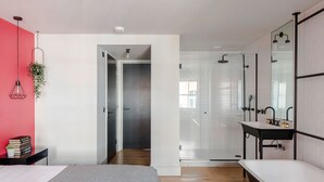 A modern bathroom with a bathtub, a large mirror, and a shower area. - The Acre Penthouse - Covent Garden - by Frankie (London)