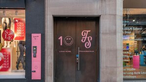 A storefront with a large 'SALE' sign, a door with '1' and 'FS' signage, and a pink vending machine. - The Acre Penthouse - Covent Garden - by Frankie (London)