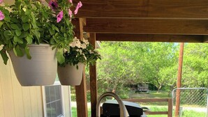 A wooden deck with a built-in sink and hanging flower pots. - Saykm Bungalow Lake Texoma walking distance to sandy beach & boat ramp (Pottsboro)