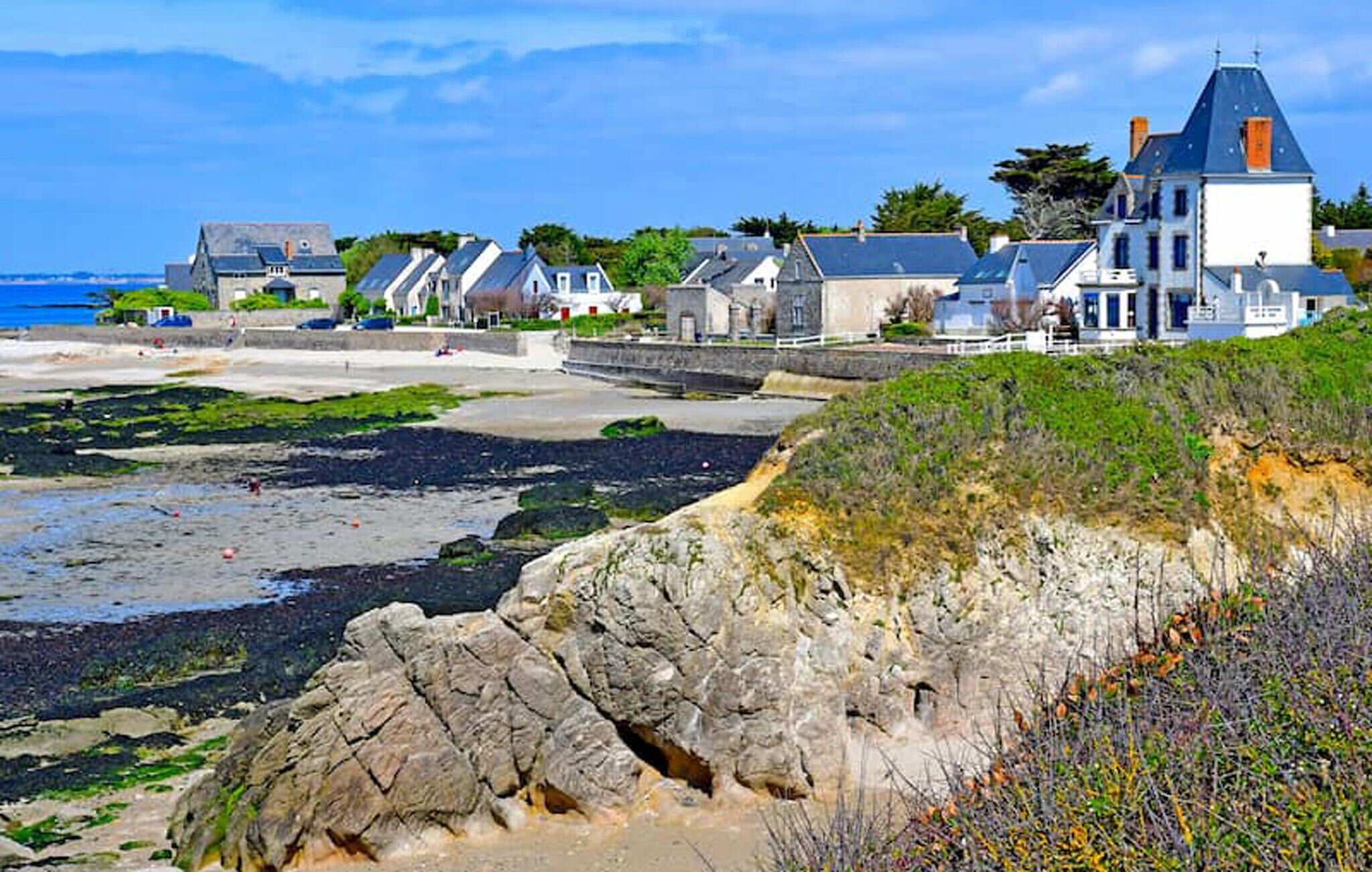 A coastal property with a large house, smaller cottages, and a rocky shoreline.