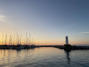 A marina with multiple sailboats docked and a lighthouse in the background. - Appt 3 pièces, wifi, parking , vue mer partielle (QUIBERON)