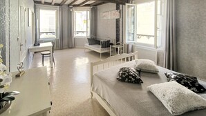 Una camera da letto con un letto, una scrivania e una sedia. Sono presenti finestre e una vista sull'esterno.