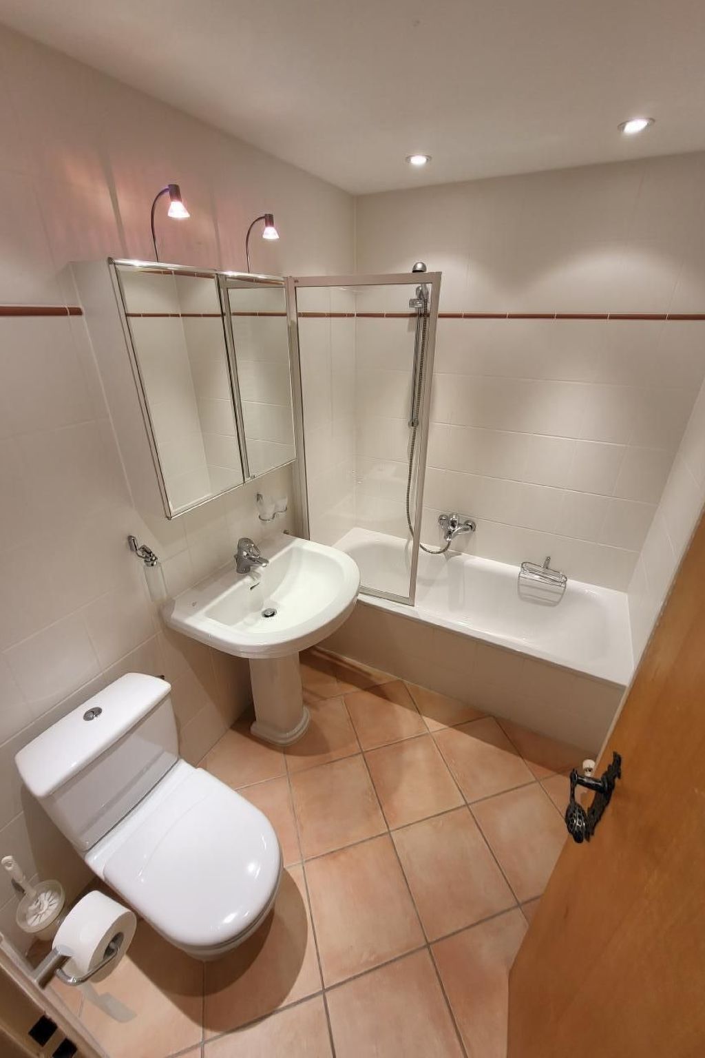 Ein modernes Badezimmer mit einer gläsernen Duschkabine, einem Standwaschbecken, einer Badewanne und einer Toilette.