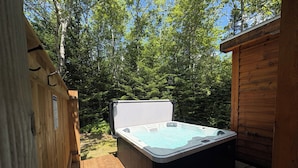 A wooden deck with a hot tub, surrounded by trees. - The Redwood Studio - Lawrencetown Lodge (West Porters Lake)