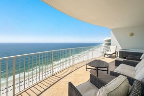 Ein Balkon mit Blick auf das Meer, Korbmöbel und einem Whirlpool.