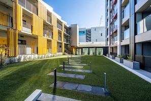 Un bâtiment moderne doté d’une cour intérieure, de balcons et d’une enseigne indiquant un magasin Samsung.