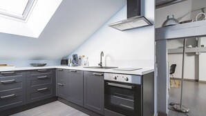 Uma cozinha moderna com claraboia, forno embutido e exaustor de aço inoxidável.
